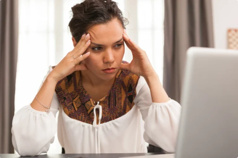 Woman with her hands on her temples looking worried