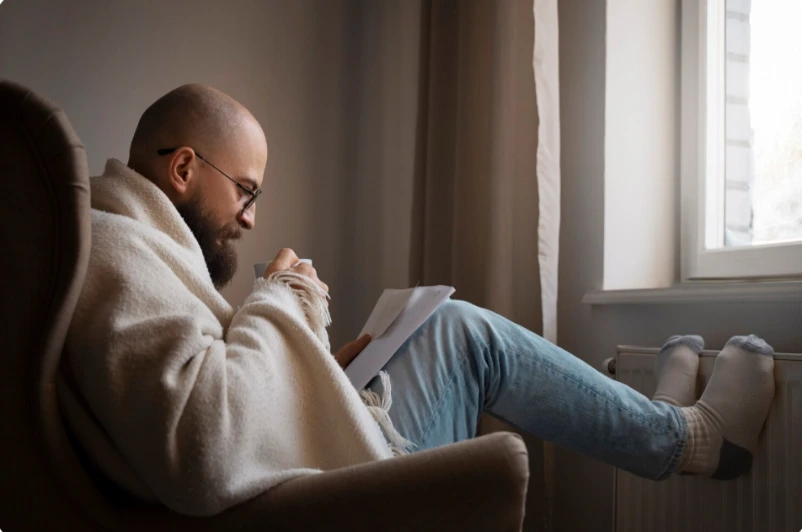 Man resting quietly by a window with a thoughtful expression
