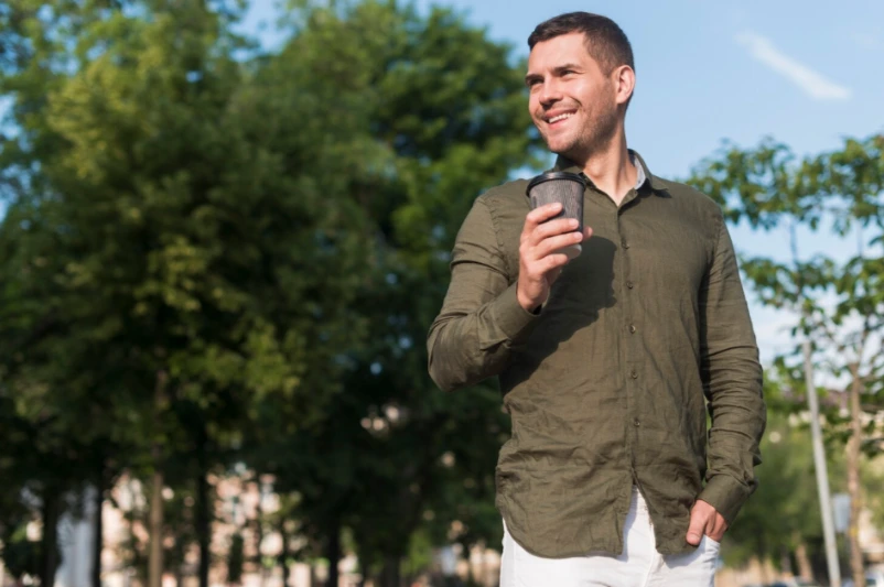 Calm happy adult man walking outdoors in morning light, peaceful after anger management classes