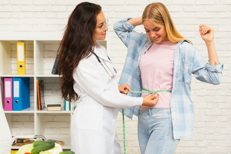 Nutritionist measuring a patient during a weight management consultation