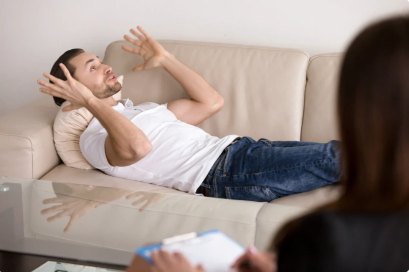 Man sitting on a couch experiencing anxiety and depression