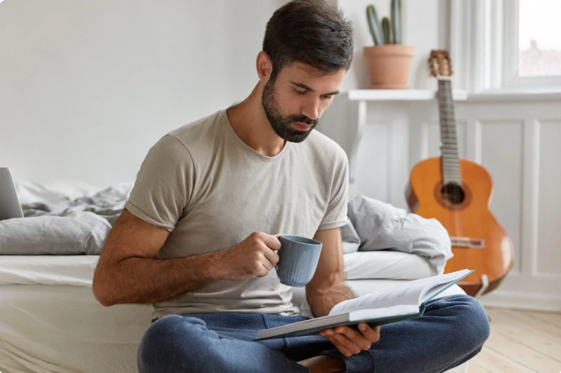 Thoughtful adult man writing in a journal in calm morning light, practicing self-reflection through anger management