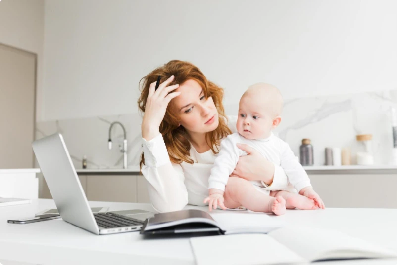 Tired mother sitting alone with her baby, overwhelmed at home, considering postpartum depression care at Harmony Health & Psychiatry
