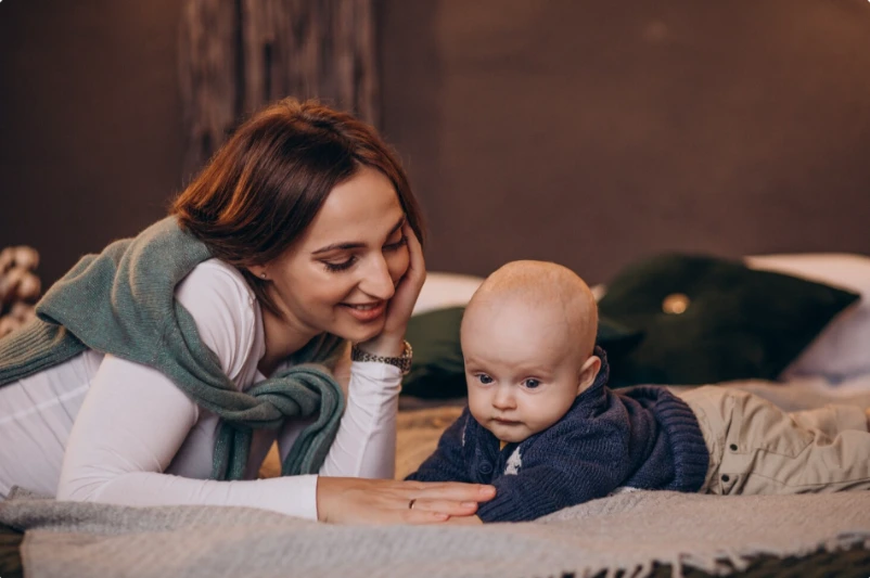 Tired new mother holding her baby at home, thoughtful and overwhelmed, seeking support for postpartum depression