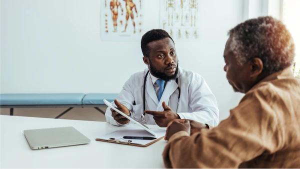 Black doctor consulting with an older patient about a treatment plan
